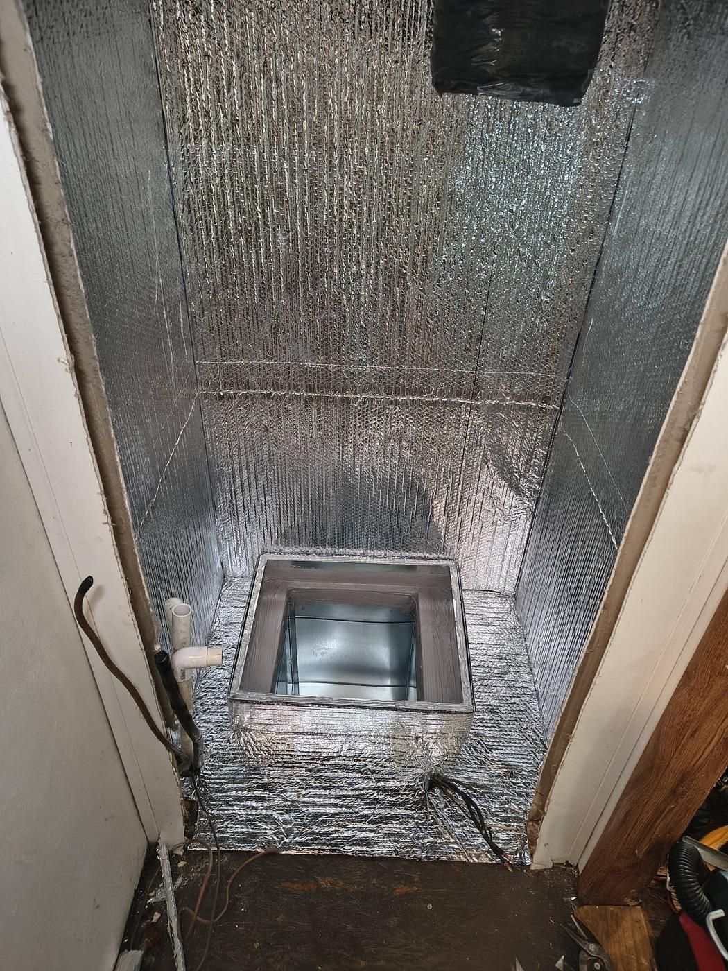 Closet lined with foil insulation around a new duct opening